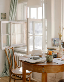 A white room with a table, a chair, and various items on top of the table