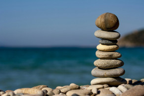 Cairn stones in front of the blue sea