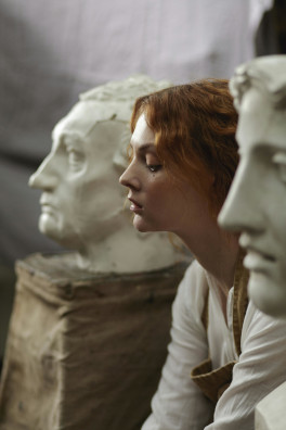 Womans's profile in the middle of two head sculptures